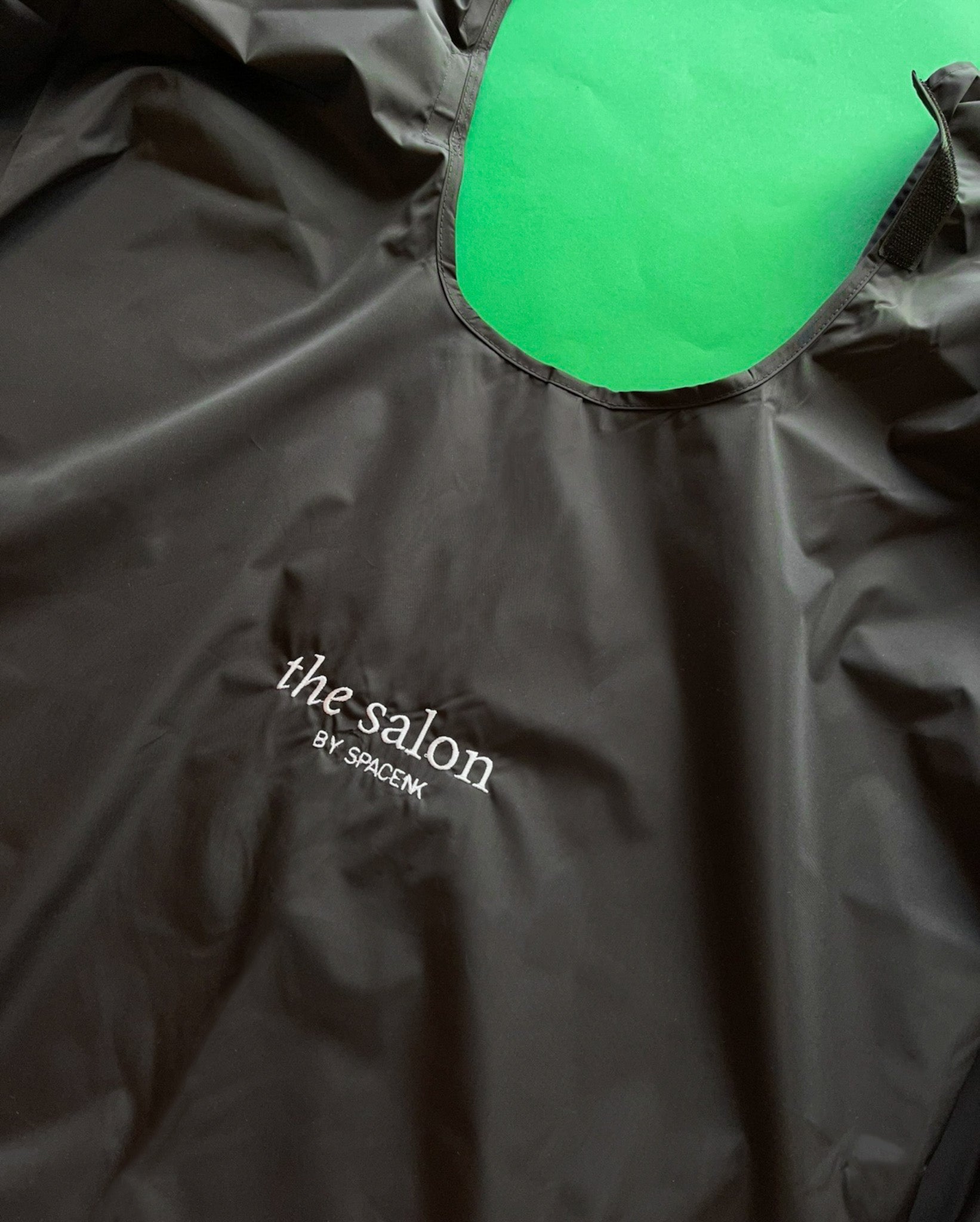 custom branded salon hairdressing cape in black with log on front